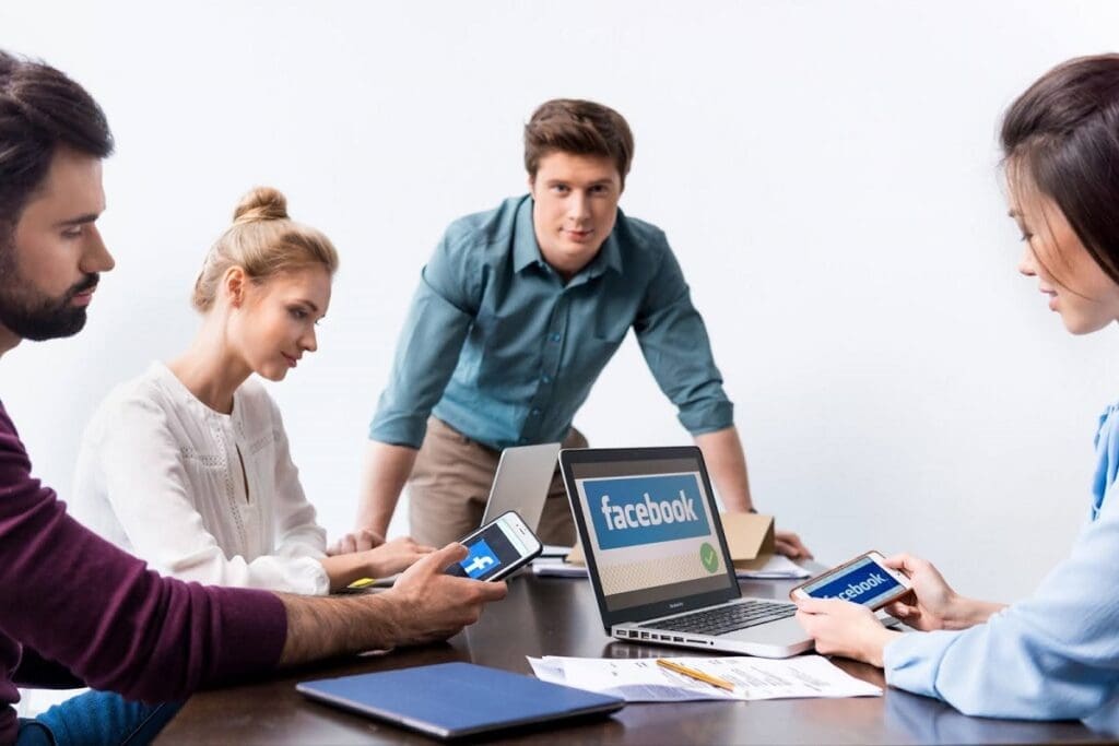 Four people looking at Facebook social media graphics on various devices